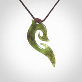 This photo shows a koru pendant carved from New Zealand Jade. The artist, Shaun Gardiner, has carved this beautifully. We provide this piece with an adjustable brown cord. This is a fantastic work of art, we have one only.